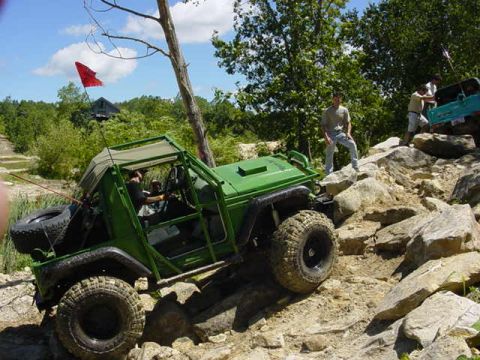 1992 Ford Bronco - Off-road vehicles tackle a challenging rocky terrain on a sunny day.