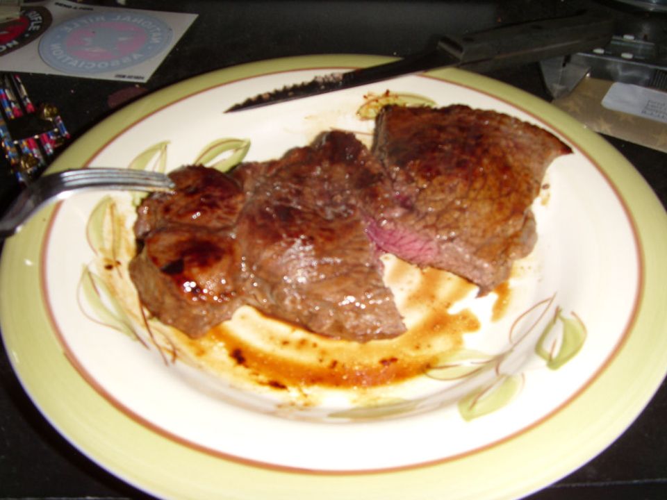 Steak on a plate with a fork and knife. Supermotors logo at bottom