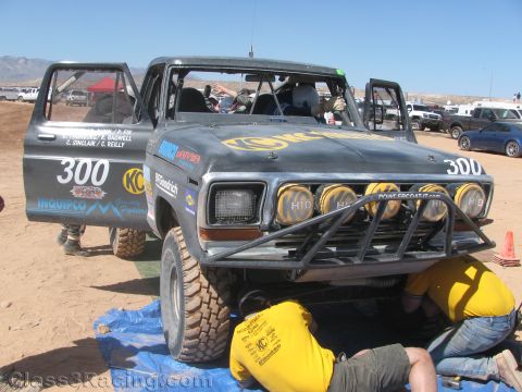1990 Ford Bronco - front of a black Ford Bronco off-road race truck numbered 300, with a row of driving lights and a tubular bumper, parked on a tarp.