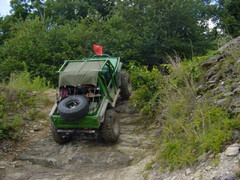 1992 Ford Bronco - An off-road vehicle navigates a challenging rocky terrain, ascending a steep incline.