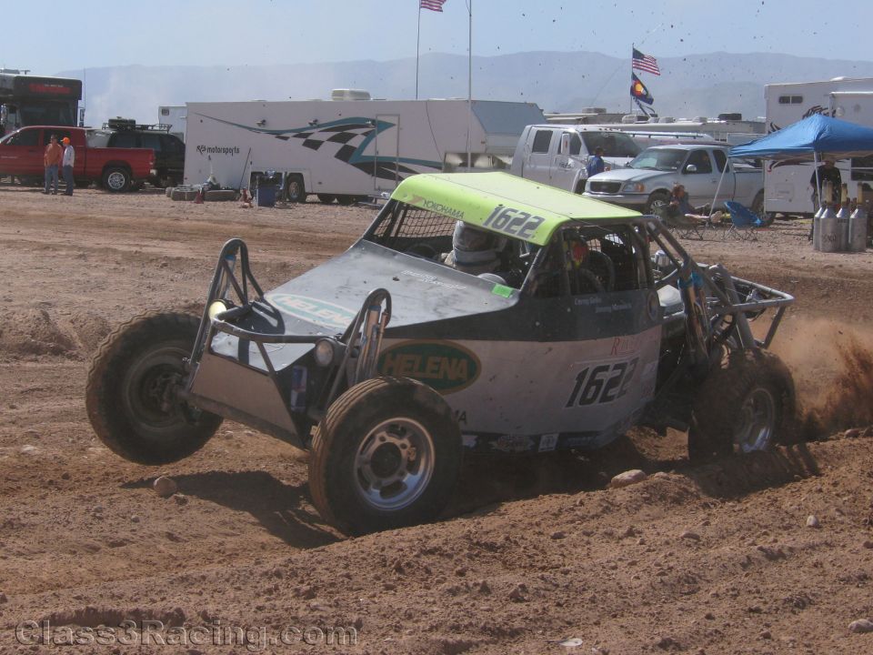 Gray off-road race buggy #1622 with green roof sliding in dirt