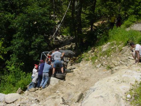 1992 Ford Bronco - A group of people attempt to free an off-road vehicle that is stuck on a challenging rocky terrain.