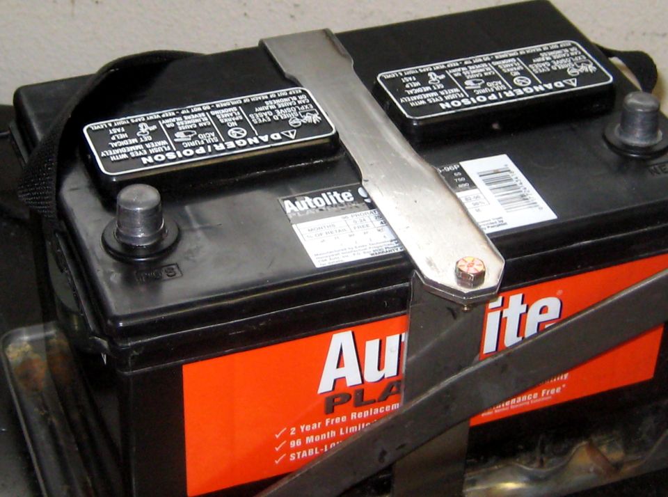 Car battery with Autolite Platinum label and metal hold-down strap