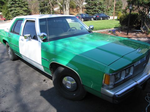 1991 Ford LTD Crown Victoria - Side three-quarter view of a green-and-white Ford sedan parked on a driveway in a residential neighborhood.