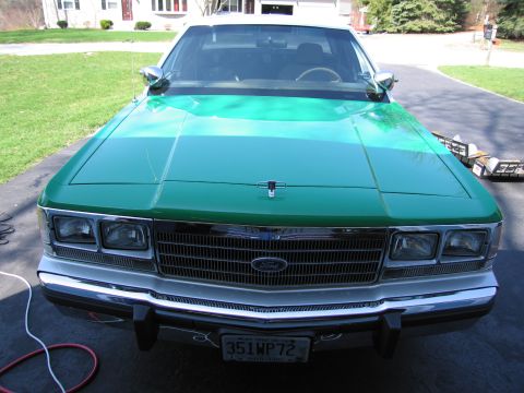 1991 Ford LTD Crown Victoria - Front view of a green Ford sedan with chrome grille, quad headlights and a license plate reading 351WP72, in a driveway.