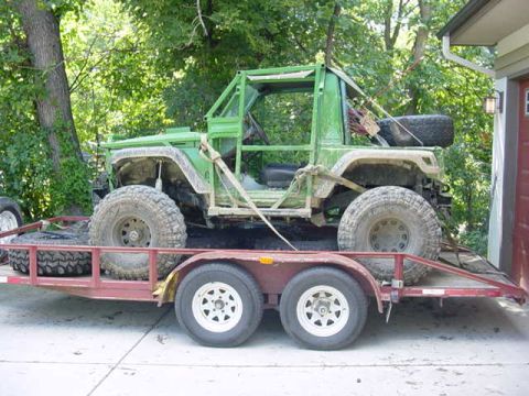 1992 Ford Bronco - A modified off-road vehicle is loaded onto a trailer, ready for transport.