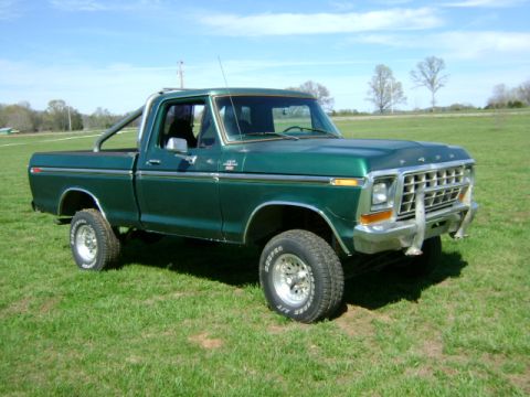 1979 Ford F-150 - This green 1979 Ford F-150 pickup truck is shown from a 3/4 front angle on a grassy field.