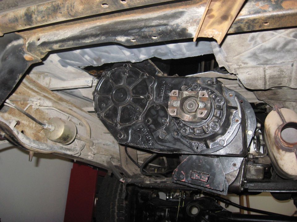 Underside view of a vehicle's transfer case and part of the exhaust system