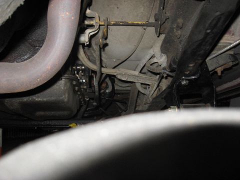 1991 Ford Bronco - Close-up view of the undercarriage of a vehicle, revealing mechanical parts and exhaust system.