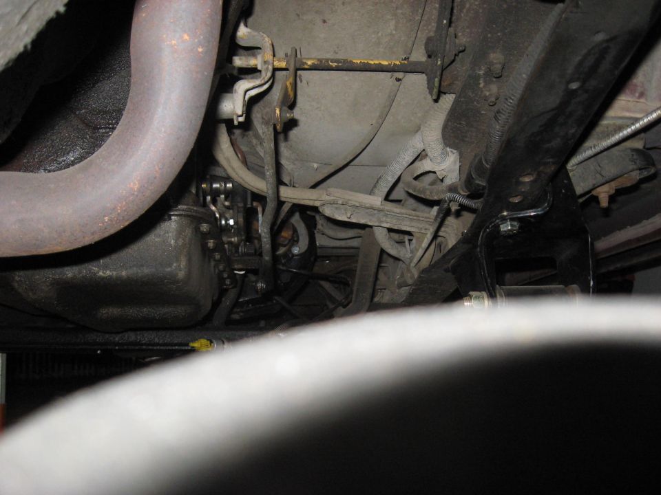 Underside of a vehicle showing exhaust pipe, transmission, and suspension components