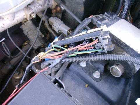 2000 Mercury Grand Marquis - A complex network of wires and connectors is visible in the engine bay, likely part of the fuse box or control module.