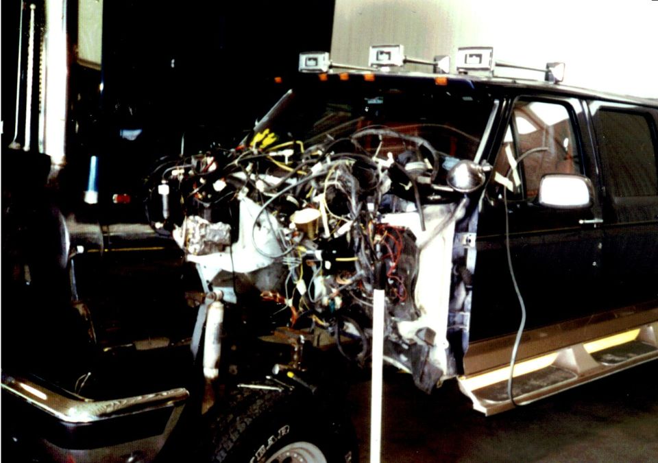 vehicle with front end disassembled, showing engine and wiring