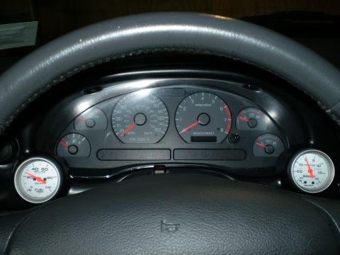 2002 Ford Mustang - The dashboard gauges of a car, including aftermarket additions for boost and fuel pressure readings.