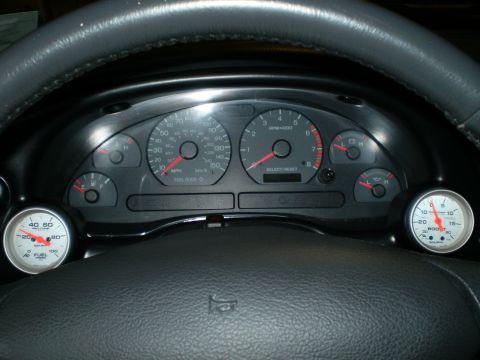 2002 Ford Mustang - Interior view of a car's dashboard, multiple gauges like the speedometer, tachometer, fuel level, and a boost gauge.