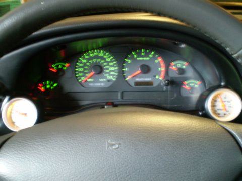 2002 Ford Mustang - Dashboard gauges in a 2002 Ford Mustang, including speedometer, tachometer, and additional monitoring instruments.