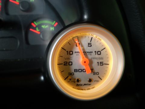 2002 Ford Mustang - Close-up of a car's interior, focusing on a lit boost gauge and oil level indicator.
