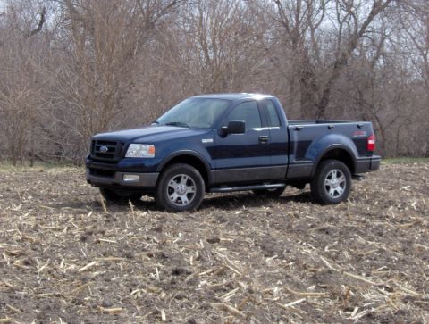 2005 Ford F-150 - Dark blue 2005 Ford F-150 FX4 flareside pickup truck in a field with dry vegetation.