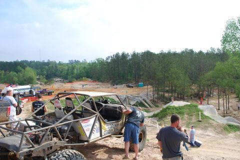 2008 Jeep Wrangler - An off-road buggy with a prominent roll cage is the focus of this scene at an outdoor event.