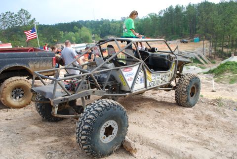 2008 Jeep Wrangler - This custom buggy appears to be at an off-road event, with a pickup truck nearby and spectators watching.