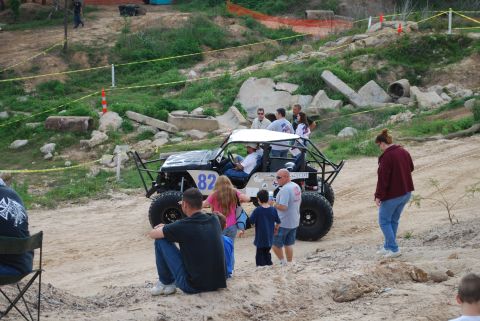 2008 Jeep Wrangler - A modified off-road buggy with several people gathered around it at an outdoor event.