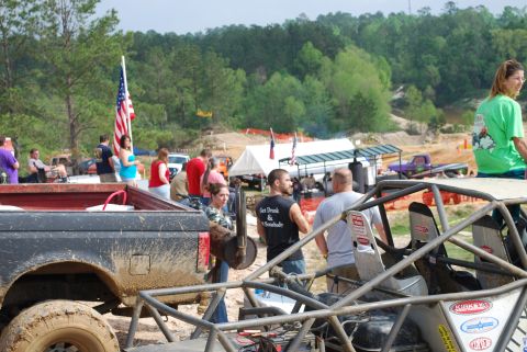 2008 Jeep Wrangler - Spectators and vehicles at an outdoor off-road event with an American flag flying.