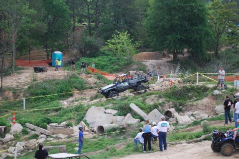 2008 Jeep Wrangler - An off-road vehicle navigates a challenging rocky course during an event, with spectators observing the action.