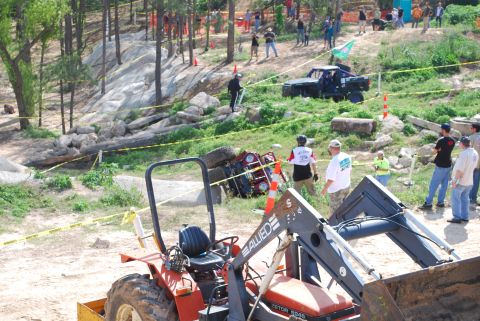 2008 Jeep Wrangler - An off-road event shows a Jeep Wrangler tipped onto its side, with a tractor nearby.