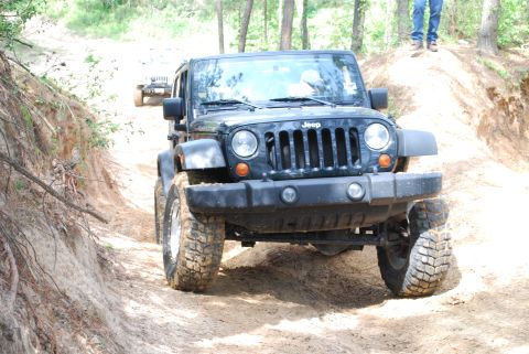 2008 Jeep Wrangler - A 2008 Jeep Wrangler navigates a sandy off-road path, with another Jeep following in the distance.