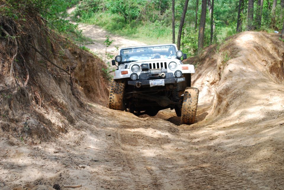 White 2008 Jeep Wrangler driving on a steep dirt trail