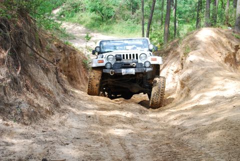 2008 Jeep Wrangler - White Jeep Wrangler navigates a challenging off-road trail.