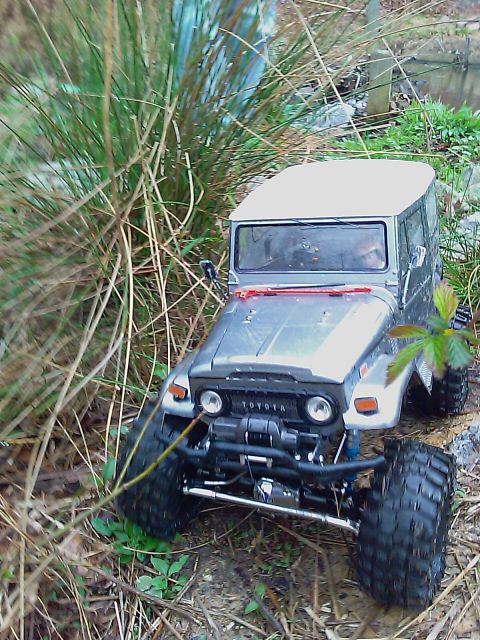 1996 Ford Bronco - Model Toyota Land Cruiser FJ40 navigates a grassy, off-road path.