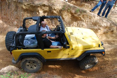 2008 Jeep Wrangler - A yellow 2008 Jeep Wrangler Rubicon navigates a steep, sandy incline during an off-road excursion.
