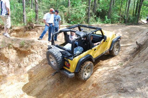 2008 Jeep Wrangler - A yellow Jeep Wrangler navigates a steep dirt path during an off-road event.