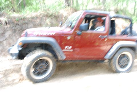 2008 Jeep Wrangler - Red 2008 Jeep Wrangler navigates a dirt road during an outdoor meetup.