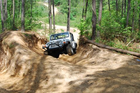 2008 Jeep Wrangler - A Jeep navigates a challenging off-road trail, with another vehicle in the distance.