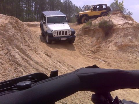 2008 Jeep Wrangler - Two Jeep Wranglers navigate a challenging off-road course, with one white model leading the way up a steep incline.