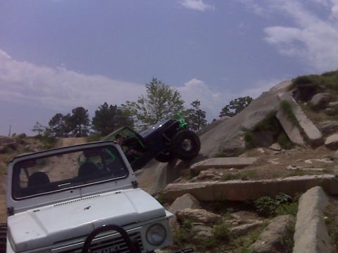 2008 Jeep Wrangler - Two off-road vehicles navigate a challenging rocky course under a cloudy sky.