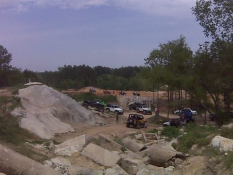 2008 Jeep Wrangler - Off-road vehicles navigate a challenging dirt park environment with rocky obstacles and wooded areas.