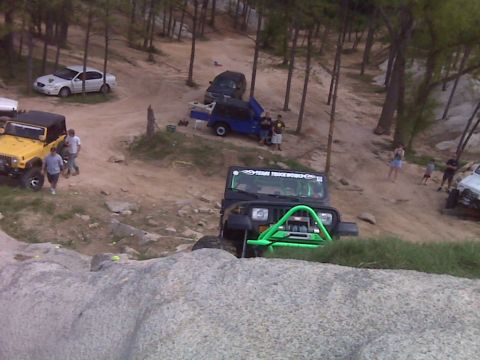 2008 Jeep Wrangler - Several off-road vehicles are gathered on a dirt path surrounded by trees.