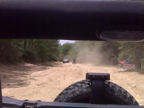 2008 Jeep Wrangler - A group of off-road vehicles kicks up dust on a dirt path during a meetup.