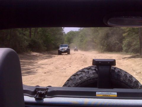 2008 Jeep Wrangler - Two Jeep Wranglers and an ATV travel down a dirt road, kicking up dust.