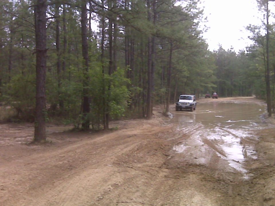 White 2007 Jeep Wrangler on muddy forest road