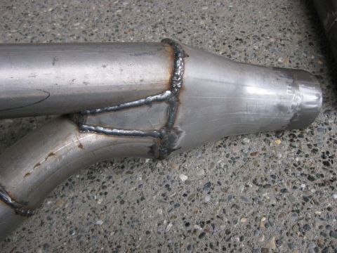 1979 Ford Bronco - A close-up view of a custom exhaust pipe section, showing the welded joints and some faint markings.