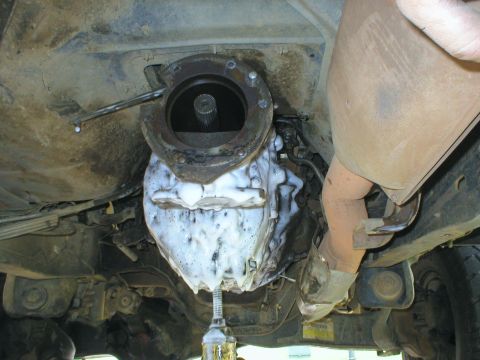 1983 Ford Bronco - The underside of a vehicle is shown with a soapy transmission and exhaust system.