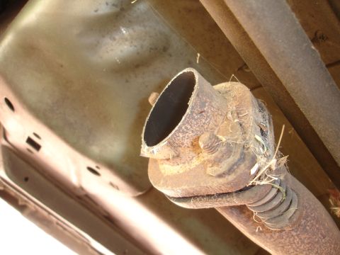 1995 Ford Taurus - Close-up view of a rusted exhaust pipe connection, showing wear and tear.