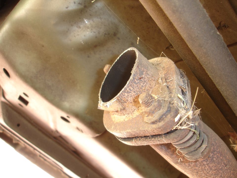 Exhaust pipe connection with rust and grass debris