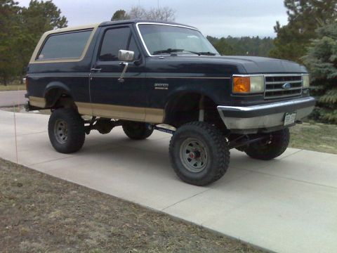 1990 Ford Bronco - This lifted Ford Bronco features a two-tone paint scheme and off-road tires.