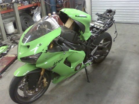 2005 Kawasaki Ninja R - A green Kawasaki Ninja motorcycle is shown in a workshop, appearing to be undergoing repairs or disassembly.