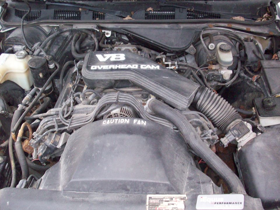 Engine bay with V8 Overhead Cam engine cover and CAUTION FAN text