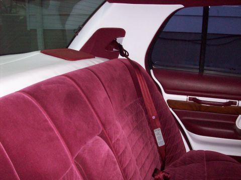 1992 Mercury Grand Marquis - The interior features plush burgundy velour seats and a contrasting white headliner, with wood trim on the door panel.